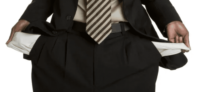Man showing empty pockets, wearing suit.